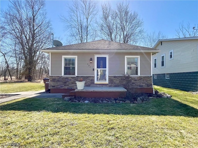 view of front facade with stone siding and a front yard