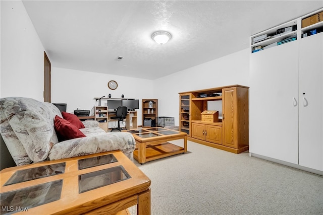 living area with visible vents, carpet floors, and a textured ceiling