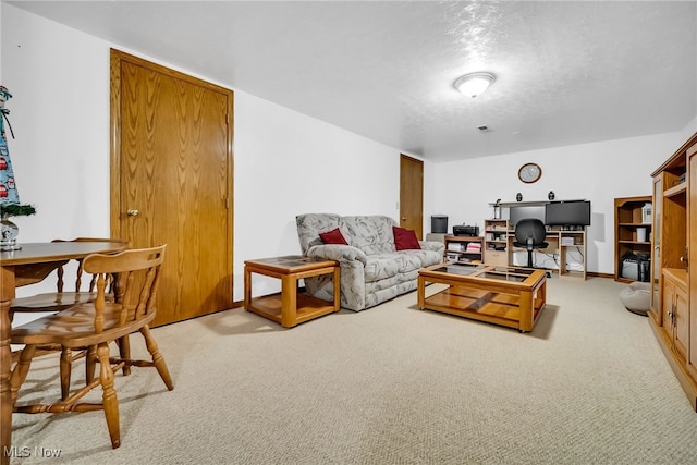 living room featuring light carpet, a textured ceiling, and baseboards