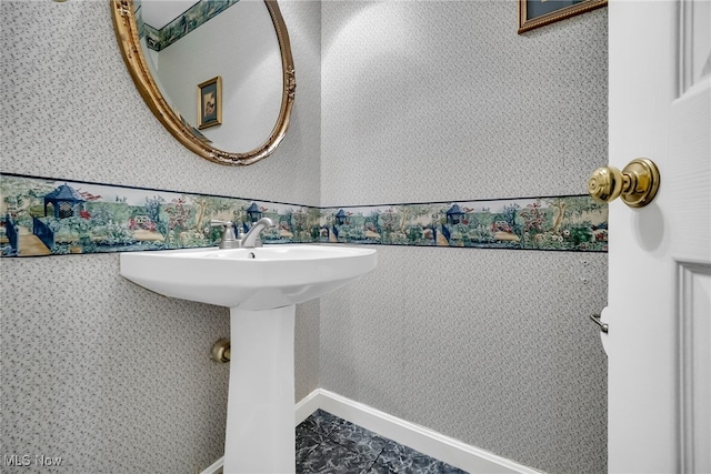 bathroom with wallpapered walls and baseboards