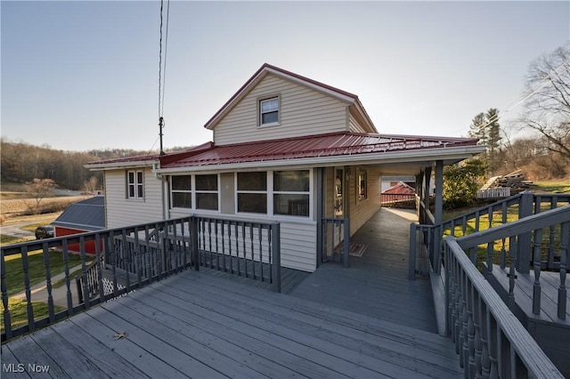 rear view of house featuring metal roof, a carport, and a deck