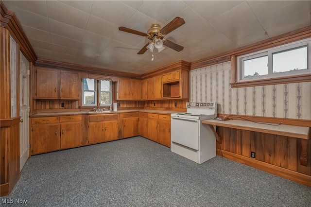 kitchen with wallpapered walls, electric range, a sink, ceiling fan, and light countertops