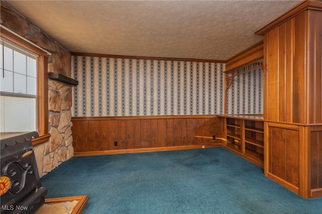 interior space with carpet flooring, wainscoting, wallpapered walls, and a textured ceiling