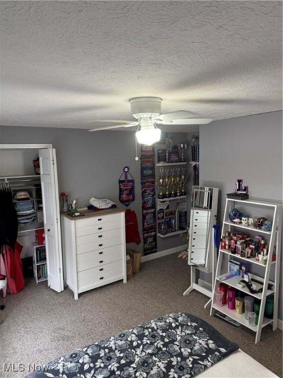 bedroom with a closet, a textured ceiling, a ceiling fan, and carpet floors