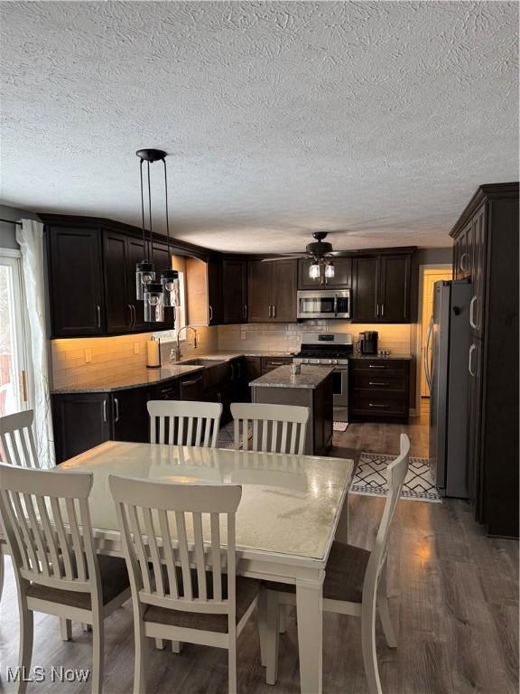 dining space with dark wood-type flooring, a ceiling fan, and a textured ceiling