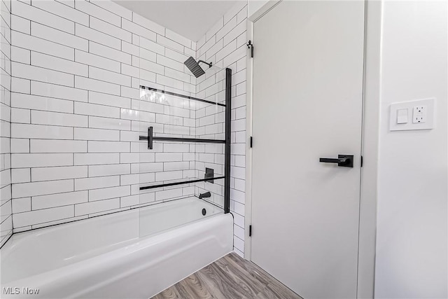 bathroom featuring  shower combination and wood finished floors