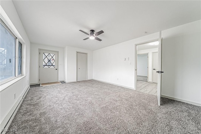 unfurnished bedroom with a baseboard heating unit, baseboards, light colored carpet, and a ceiling fan