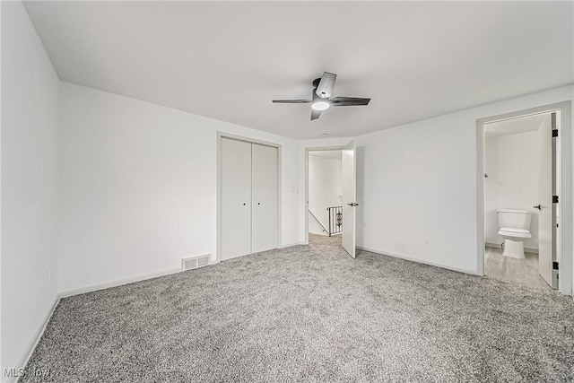 unfurnished bedroom featuring connected bathroom, ceiling fan, baseboards, carpet floors, and a closet