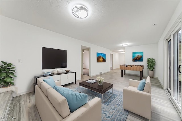 living area with light wood-style flooring and baseboards