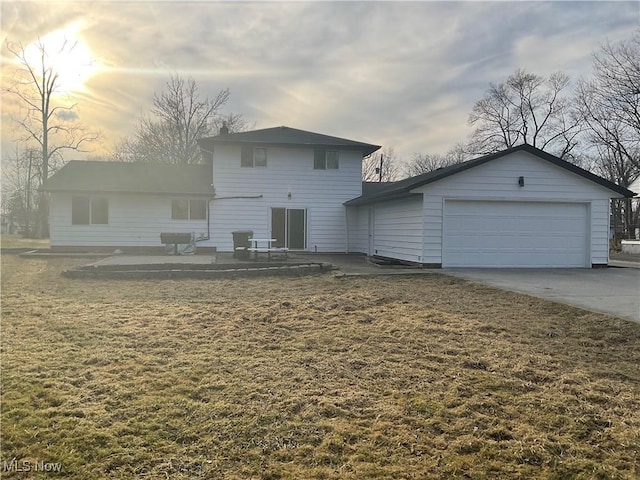 view of front facade with a front yard, concrete driveway, and an attached garage