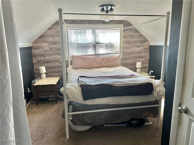 bedroom with carpet, wooden walls, and vaulted ceiling