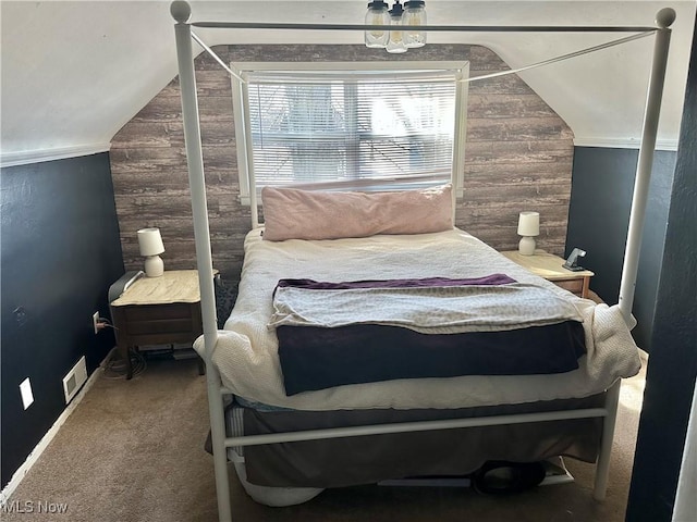 bedroom featuring lofted ceiling, carpet flooring, visible vents, and wood walls