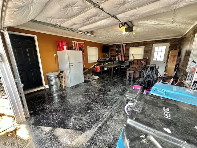 garage with a garage door opener and freestanding refrigerator