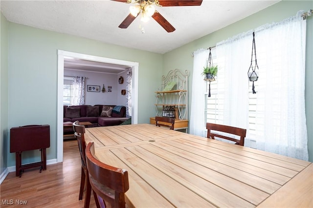 dining area featuring baseboards, wood finished floors, a textured ceiling, and ceiling fan