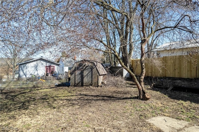 view of yard with an outbuilding, a storage unit, and fence