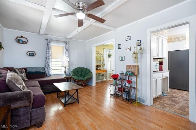 living room featuring beam ceiling, light wood-style flooring, coffered ceiling, and ceiling fan