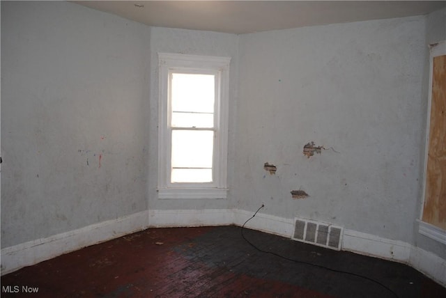 empty room featuring visible vents and wood-type flooring