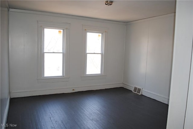 empty room featuring dark wood-style floors and visible vents