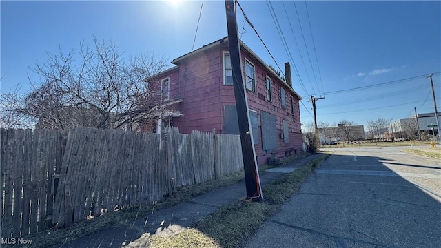 view of property exterior with fence and driveway