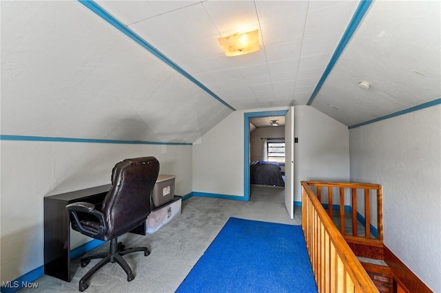 carpeted office featuring baseboards and lofted ceiling