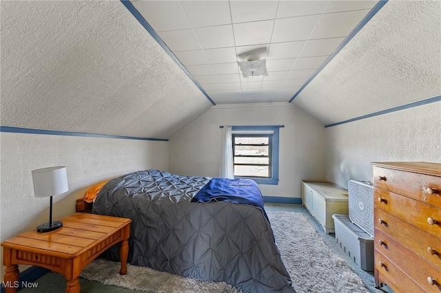 carpeted bedroom featuring a textured ceiling, lofted ceiling, and a textured wall