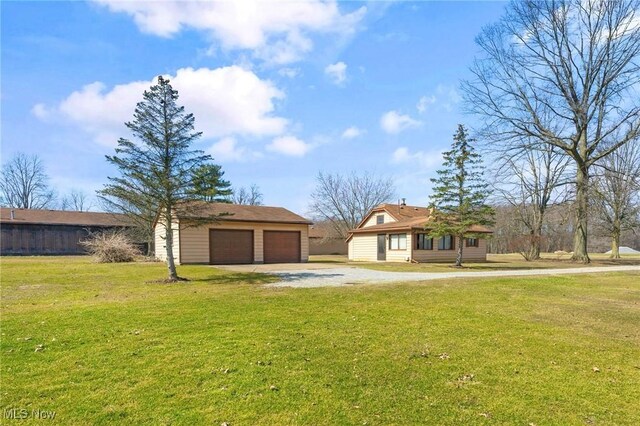 view of front facade featuring a garage, a front lawn, and an outdoor structure