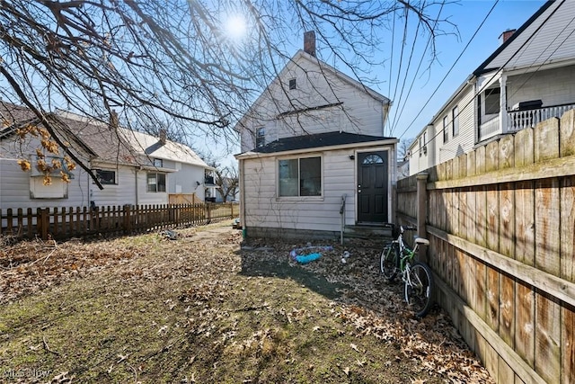 back of property with entry steps and fence