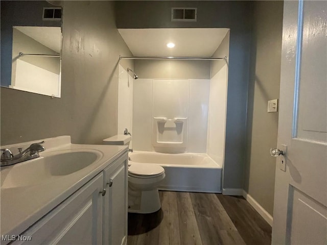 bathroom with visible vents, toilet, shower / bath combination, wood finished floors, and vanity