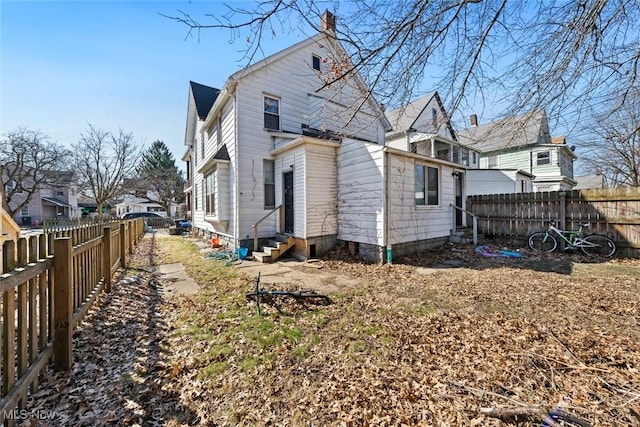 back of house with a residential view, entry steps, and a fenced backyard