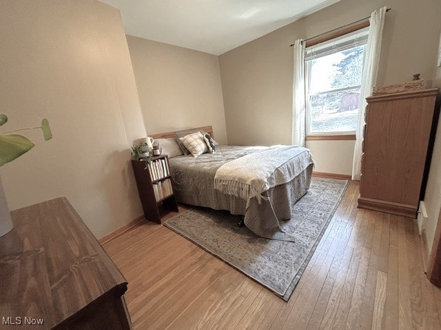 bedroom featuring baseboards and light wood finished floors