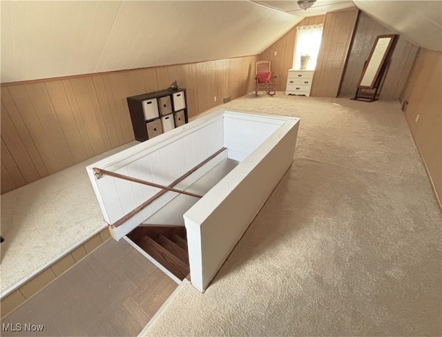 bonus room with wooden walls, lofted ceiling, and carpet