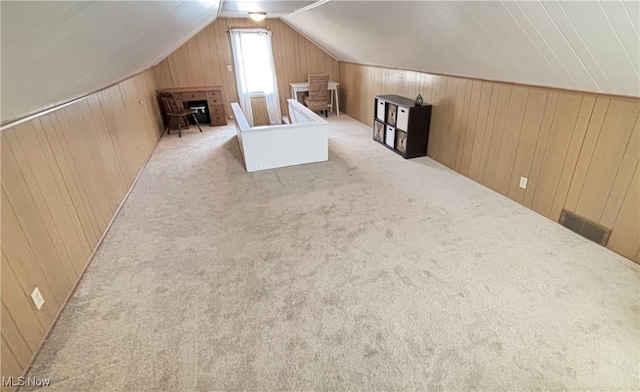 bonus room with lofted ceiling, carpet, visible vents, and wood walls