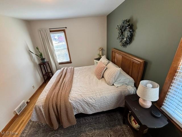 bedroom with visible vents and wood finished floors