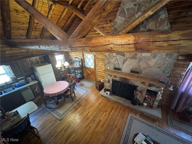 living room with hardwood / wood-style floors, a fireplace, wooden ceiling, rustic walls, and a notable chandelier