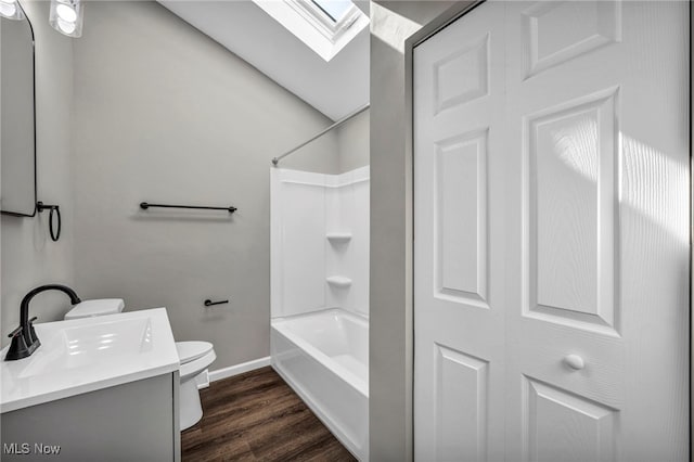 bathroom featuring vanity, wood finished floors,  shower combination, a skylight, and toilet