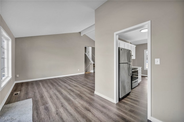 interior space featuring dark wood finished floors, visible vents, vaulted ceiling with beams, and baseboards