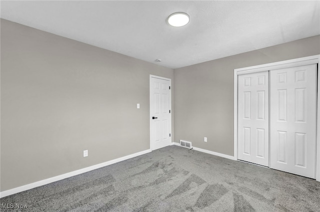 unfurnished bedroom with carpet flooring, baseboards, visible vents, and a closet