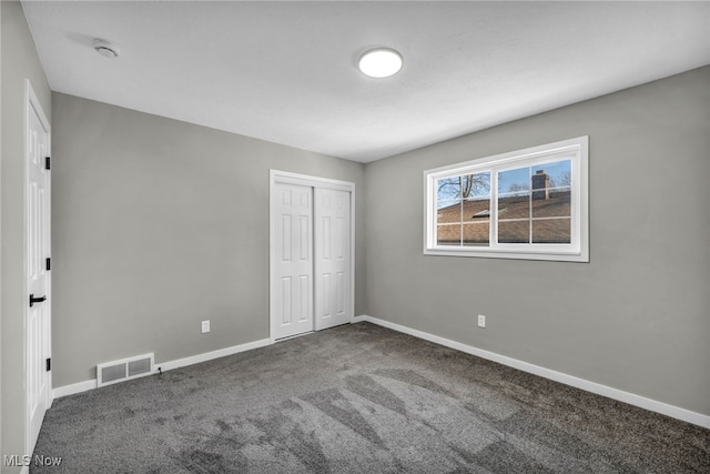 unfurnished bedroom featuring visible vents, baseboards, a closet, and carpet flooring