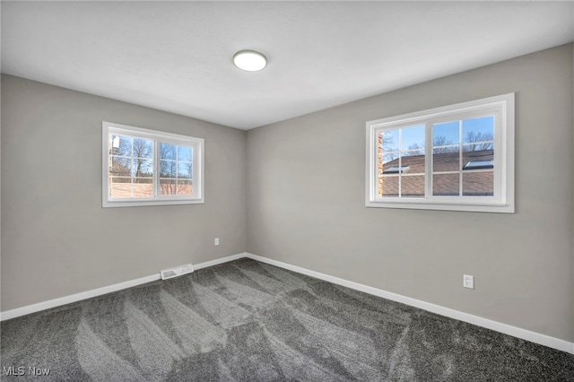 spare room with visible vents, carpet, and baseboards