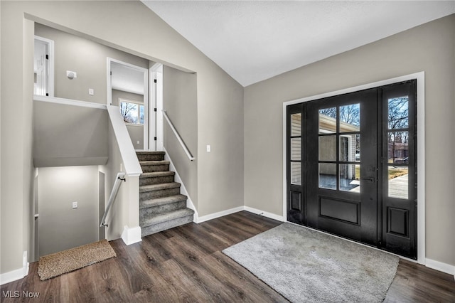 foyer with lofted ceiling, baseboards, and dark wood-type flooring