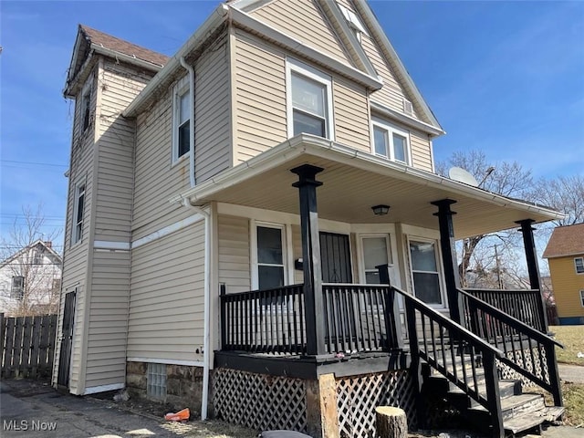 view of front of home featuring a porch and fence