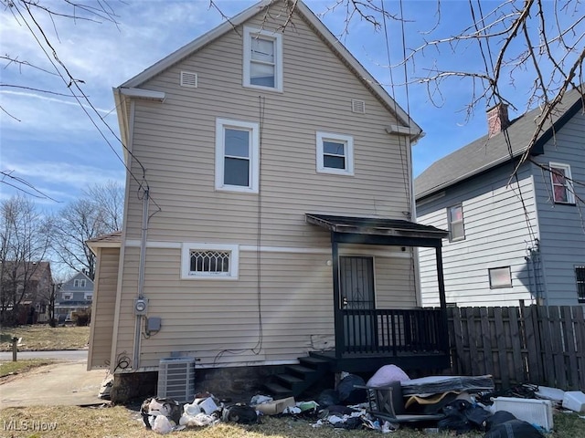 back of property featuring central air condition unit and fence