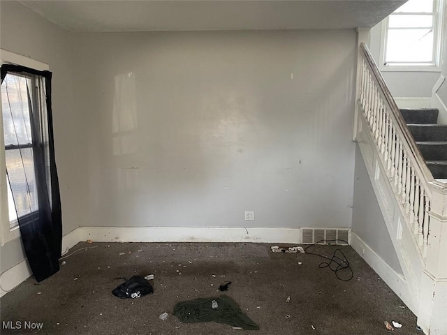 spare room with visible vents, baseboards, and stairs