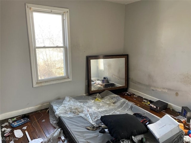 bedroom with baseboards and wood finished floors