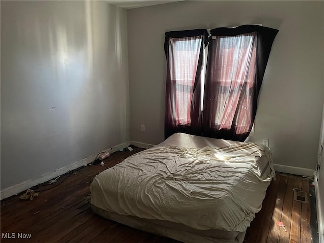 bedroom with hardwood / wood-style floors and baseboards