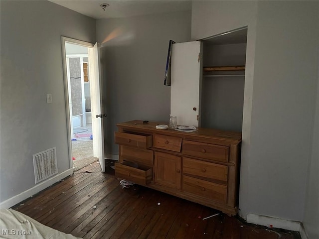 bedroom featuring visible vents, baseboards, a closet, and dark wood-style floors