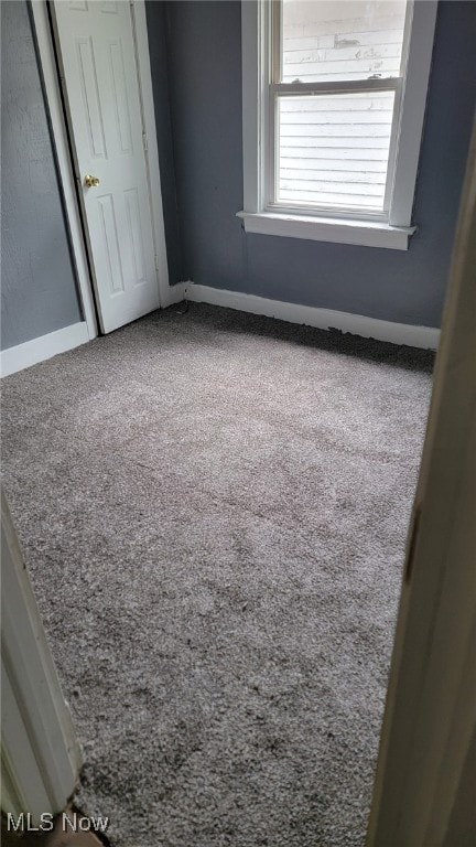 unfurnished bedroom with baseboards, carpet floors, and a closet