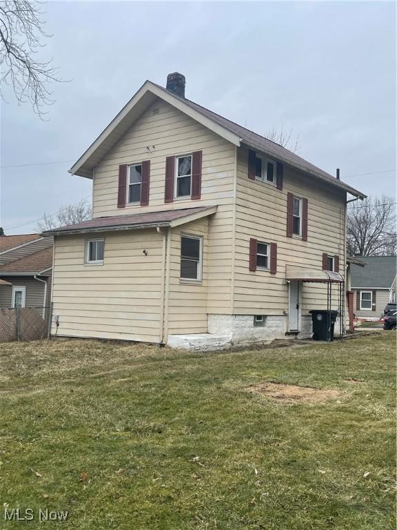 rear view of property with a yard and a chimney