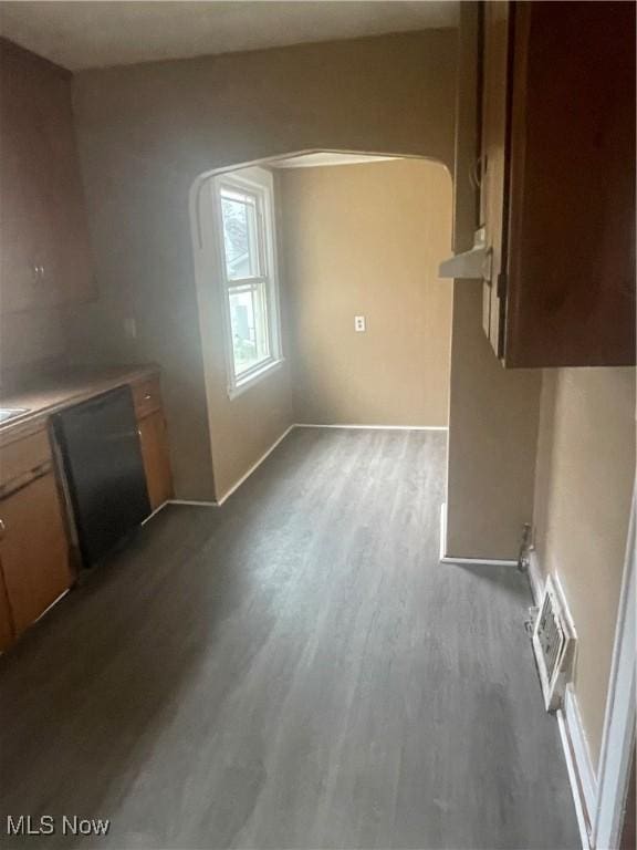 interior space with dishwashing machine, dark wood-style floors, visible vents, arched walkways, and light countertops