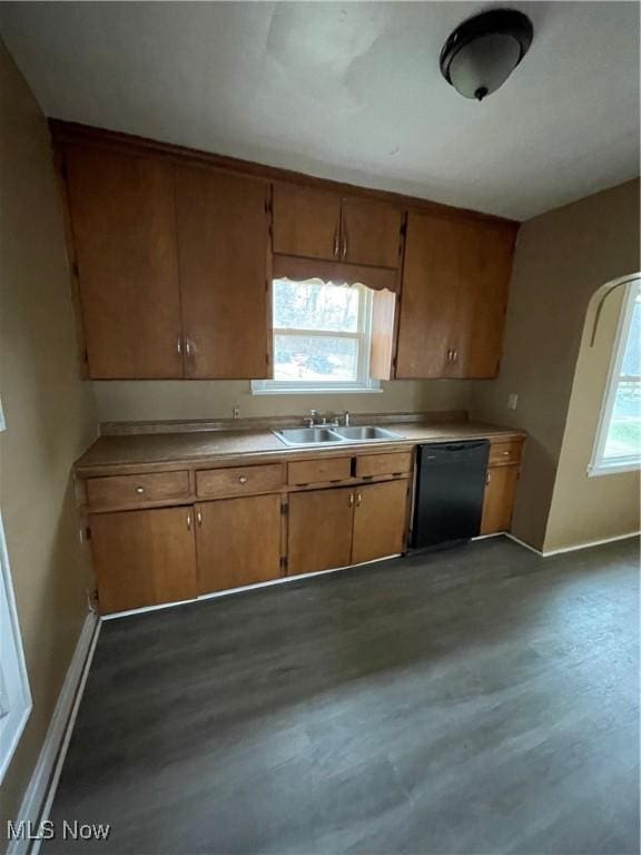 kitchen featuring a sink, brown cabinets, dishwasher, and light countertops